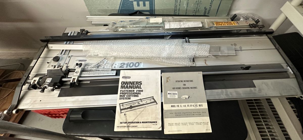 Equipment Lot: Wizard 8000 CMC Mat Cutter, Xenetech XOT 1313 Engraver, ITW AMP VN4 Frame Joiner, Fletcher 3000 60″ Multi Material Cutter, Seal Masterpiece 500T-X Mechanical Heat Press, Cavalier Porta-Wrap II 32″ Shrink Wrapper / Wrapping System, Porter Cable Model 7700 10″ Miter Saw, Hansen Foot Chopper with Measuring Table, & Fletcher 2100 48″ Mat Cutter (Used) Item # UE-071223B